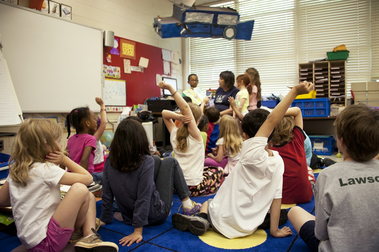 Students raising their hands in an inclusive classroom